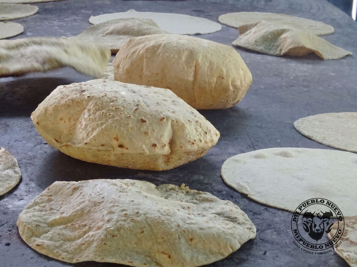Tortillas hechas a mano inflándose sobre el comal